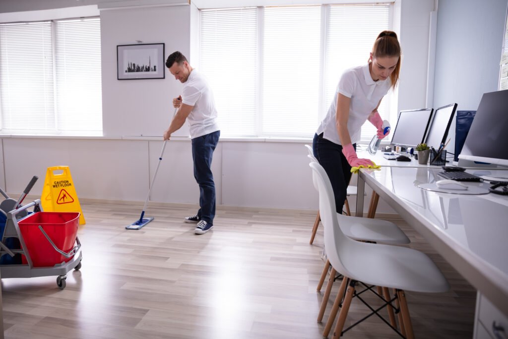smiling two young janitor cleaning the office smiling two young janitor cleaning the office