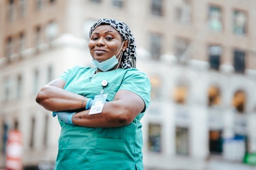 pexels photo 6098047 6098047 1 Proud nurse with arms crossed, in uniform, outdoors, urban setting, showing confidence and professionalism.